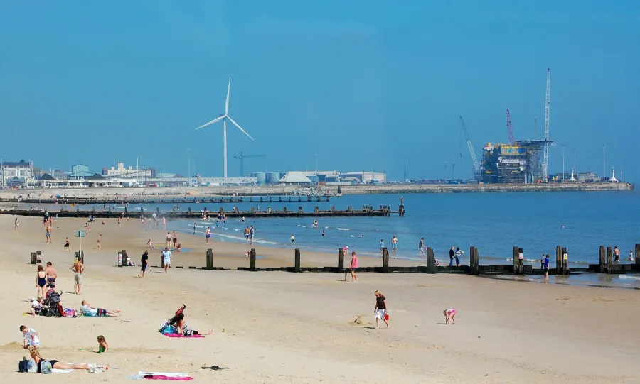 Lowestoft seafront showing the beach and the outer harbour with wind turbine and gas rig.