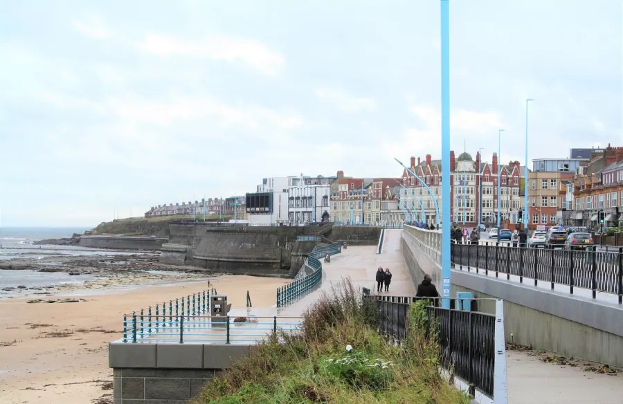 A few people braving the elements on an October day of high temperatures but also rain., Whitley Bay